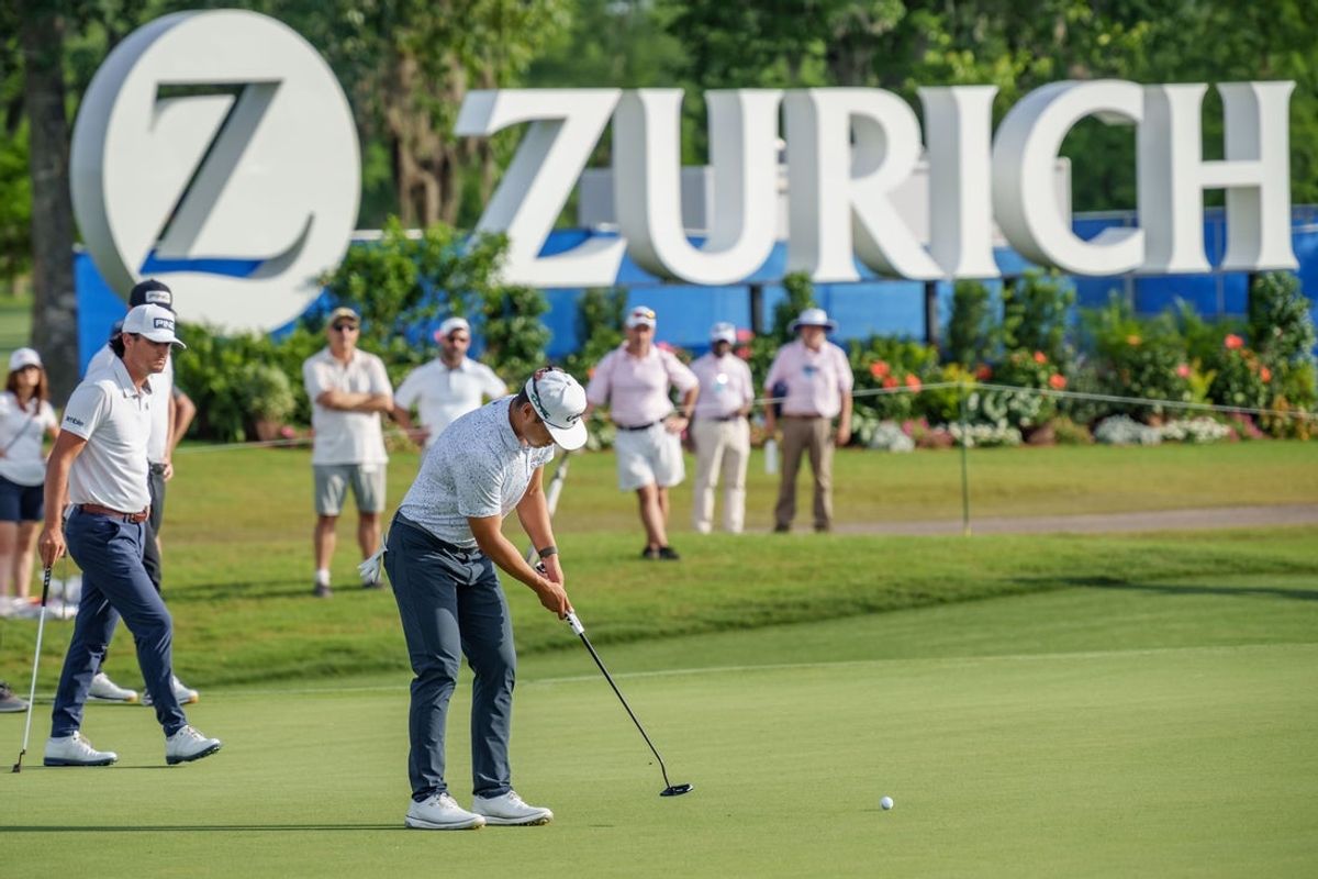 Apr 25, 2025; Avondale, Louisiana, USA; Isaiah Salinda putts on the 9th hole as teammate Kevin Velo, left, watches during the second round of the Zurich Classic of New Orleans golf tournament. Mandatory Credit: Matthew Hinton-Imagn Images