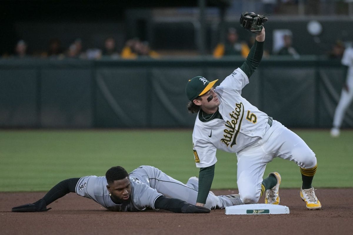 Apr 25, 2025; West Sacramento, California, USA; Athletics shortstop Jacob Wilson (5) tags out Chicago White Sox outfielder Luis Robert Jr. (88) on an attempted steal during the third inning at Sutter Health Park. Mandatory Credit: Ed Szczepanski-Imagn Images