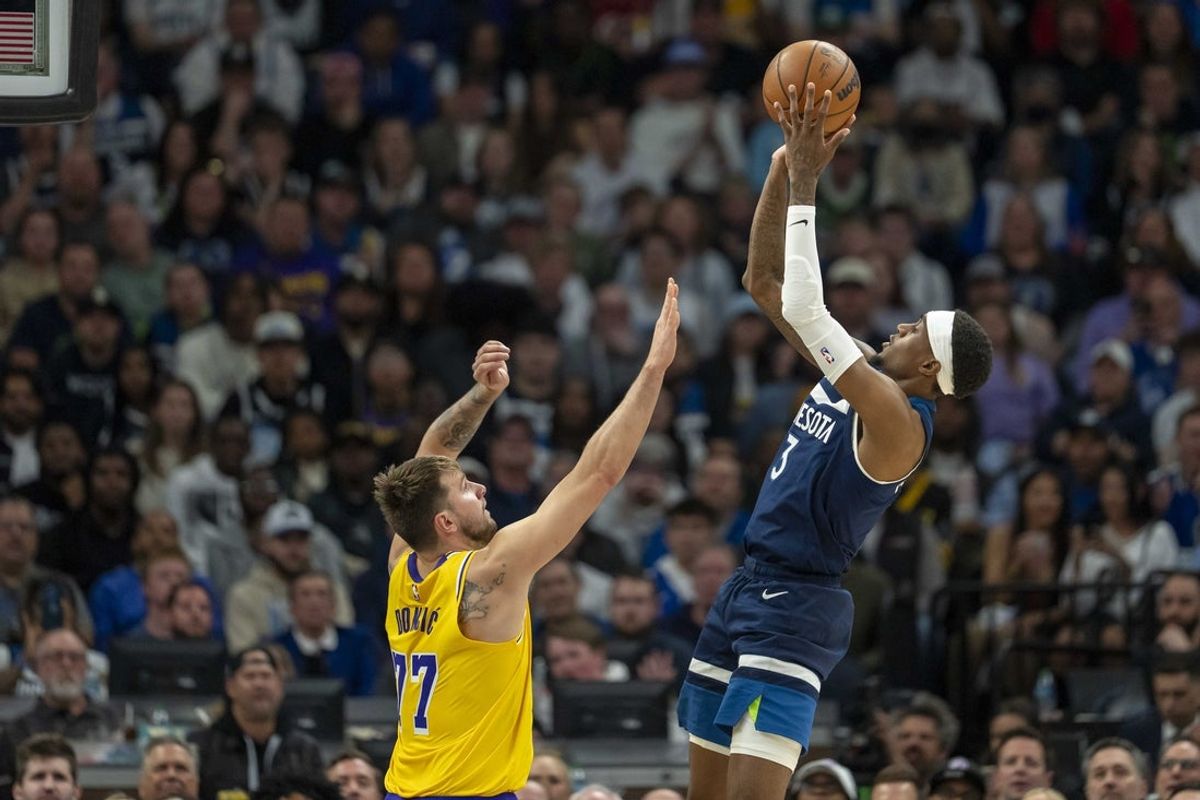Apr 25, 2025; Minneapolis, Minnesota, USA; Minnesota Timberwolves forward Jaden McDaniels (3) shoots the ball over Los Angeles Lakers guard Luka Doncic (77) in the first half during game three of first round for the 2024 NBA Playoffs at Target Center. Mandatory Credit: Jesse Johnson-Imagn Images