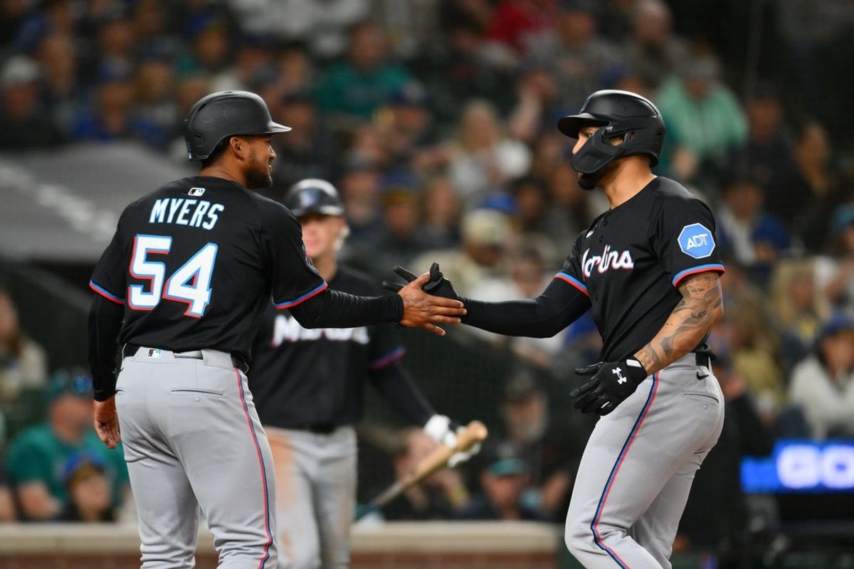 Apr 25, 2025; Seattle, Washington, USA; Miami Marlins pitch runner Dane Meyers (54) and designated hitter Agustin Ramirez (50) celebrate after Ramirez hit a 2-run home run against the Seattle Mariners during the eighth inning at T-Mobile Park. Mandatory Credit: Steven Bisig-Imagn Images