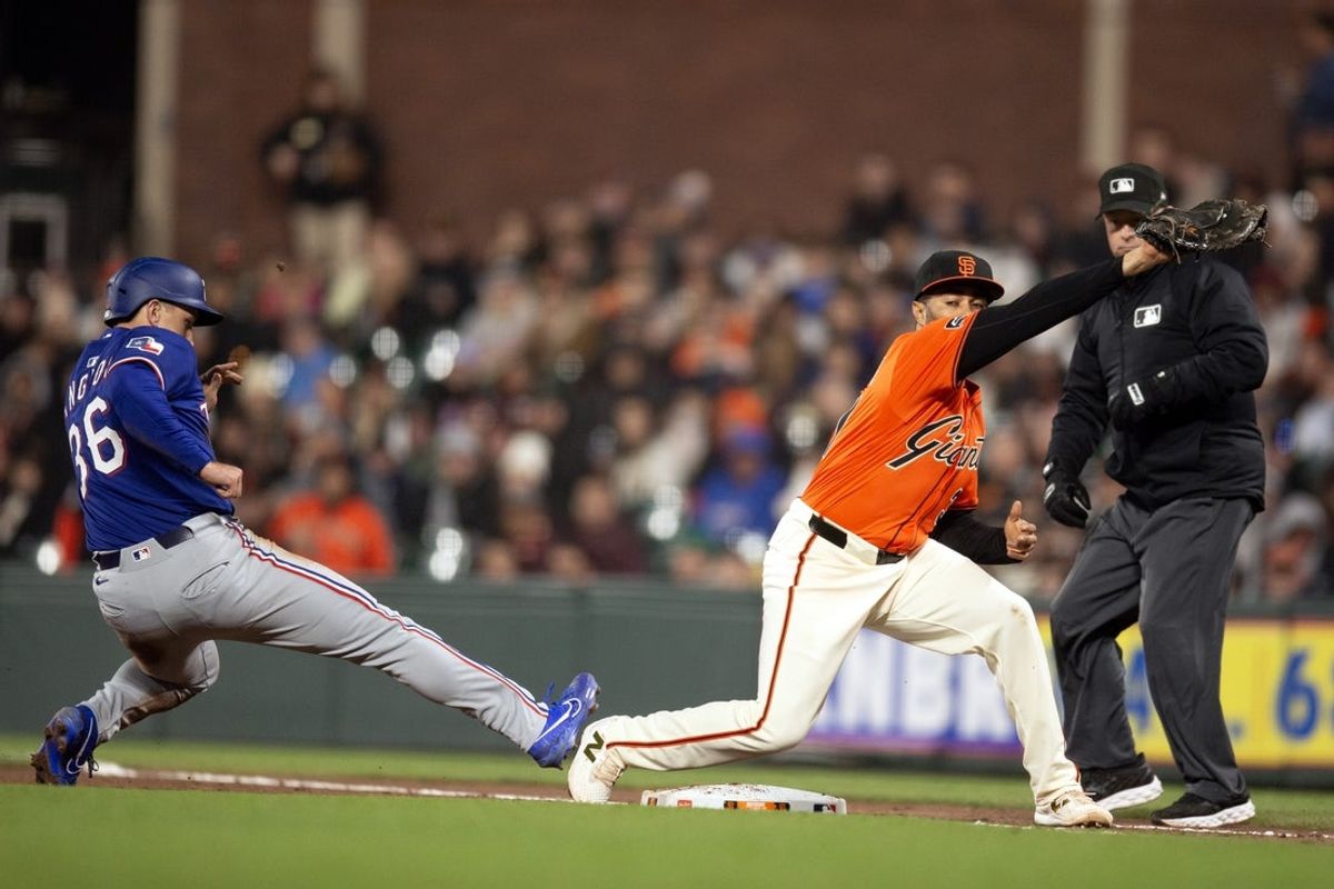 Apr 25, 2025; San Francisco, California, USA; Texas Rangers left fielder Wyatt Langford (36) gets back to first base ahead of a pickoff throw to San Francisco Giants first baseman LaMonte Wade Jr. (31) during the eighth inning at Oracle Park. Umpire is Todd Tichenor. Mandatory Credit: D. Ross Cameron-Imagn Images