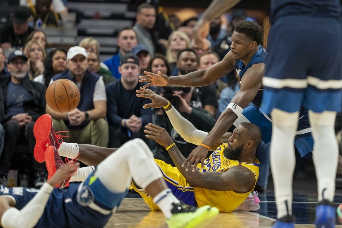 Apr 25, 2025; Minneapolis, Minnesota, USA; Los Angeles Lakers forward LeBron James (23) passes the ball from the ground as Minnesota Timberwolves guard Anthony Edwards (5) pls defense in the first half during game three of first round for the 2024 NBA Playoffs at Target Center. Mandatory Credit: Jesse Johnson-Imagn Images