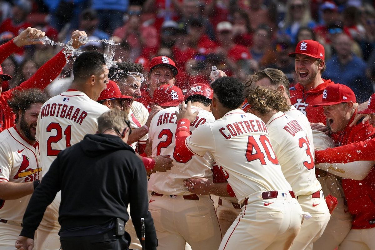 Apr 26, 2025; St. Louis, Missouri, USA;  St. Louis Cardinals third baseman Nolan Arenado (28) is mobbed by teammates after hitting a solo walk-off home run against the Milwaukee Brewers during the ninth inning at Busch Stadium. Mandatory Credit: Jeff Curry-Imagn Images