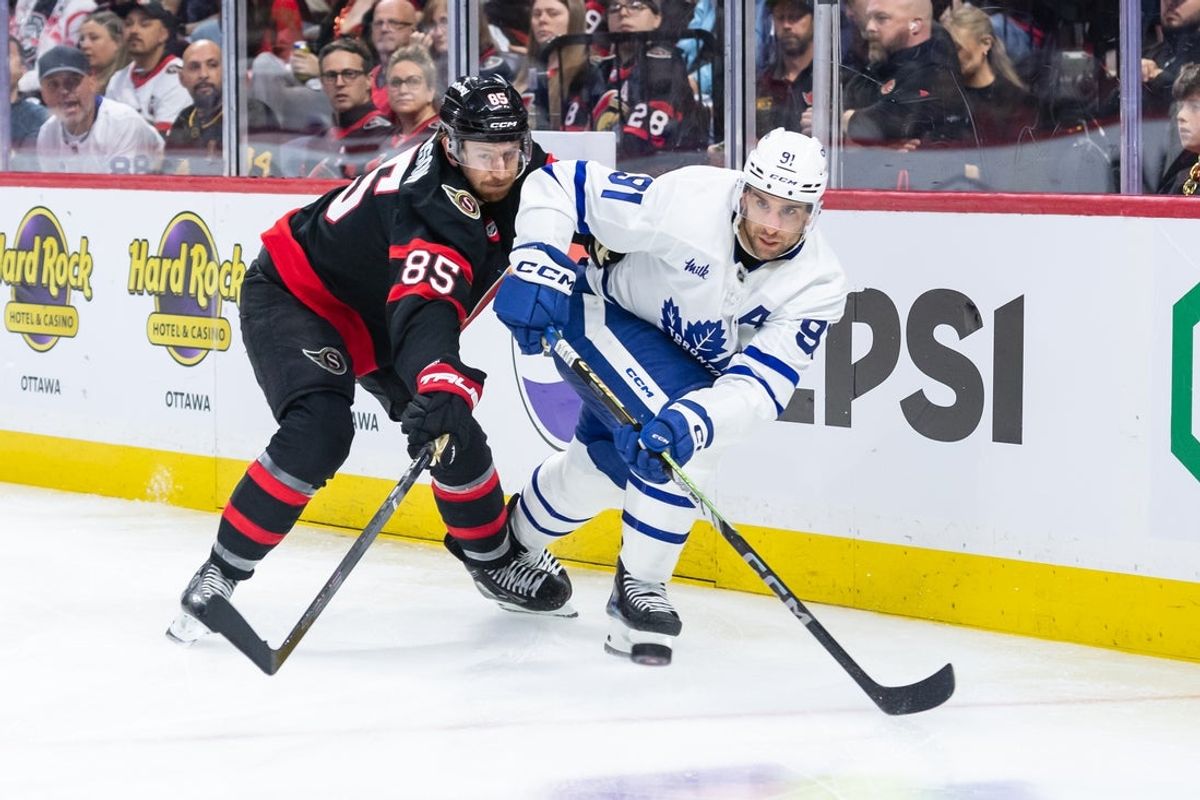 Apr 26, 2025; Ottawa, Ontario, CAN; Toronto Maple Leafs center John Tavares (91) shoots the puck away from Ottawa Senators defenseman Jake Sanderson (85) in game four of the first round of the 2025 Stanley Cup Playoffs at Canadian Tire Centre. Mandatory Credit: Marc DesRosiers-Imagn Images