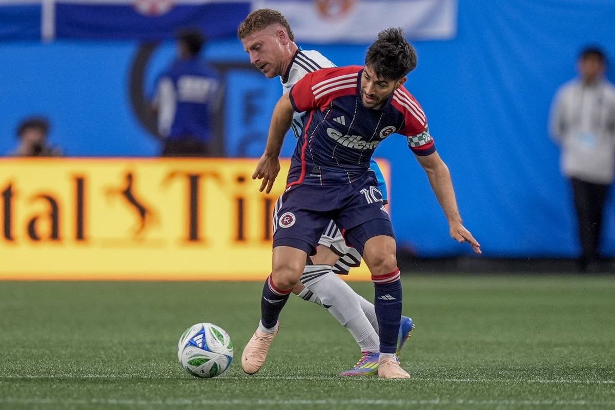 Apr 26, 2025; Charlotte, North Carolina, USA;  Charlotte FC midfielder Pep Biel (16) pressures New England Revolution midfielder Carles Gil (10) during the first half at Bank of America Stadium. Mandatory Credit: Jim Dedmon-Imagn Images
