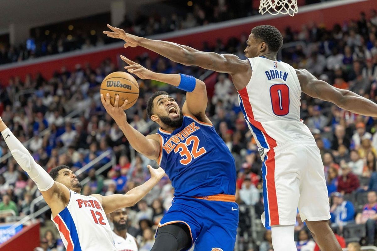 Apr 27, 2025; Detroit, Michigan, USA; New York Knicks center Karl-Anthony Towns (32) drives to the basket between Detroit Pistons center Jalen Duren (0) and forward Tobias Harris (12) during the second quarter of game four of first round for the 2025 NBA Playoffs at Little Caesars Arena. Mandatory Credit: David Reginek-Imagn Images
