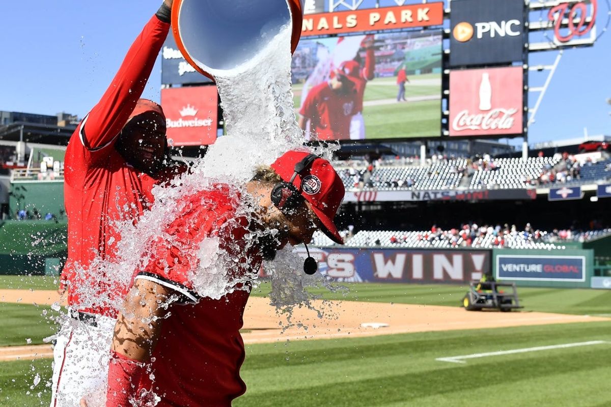Apr 27, 2025; Washington, District of Columbia, USA; Washington Nationals second baseman Luis Garcia Jr. (2) is doused with water by first baseman Josh Bell (19) after a walk-off hit against the New York Mets at Nationals Park. Mandatory Credit: Brad Mills-Imagn Images