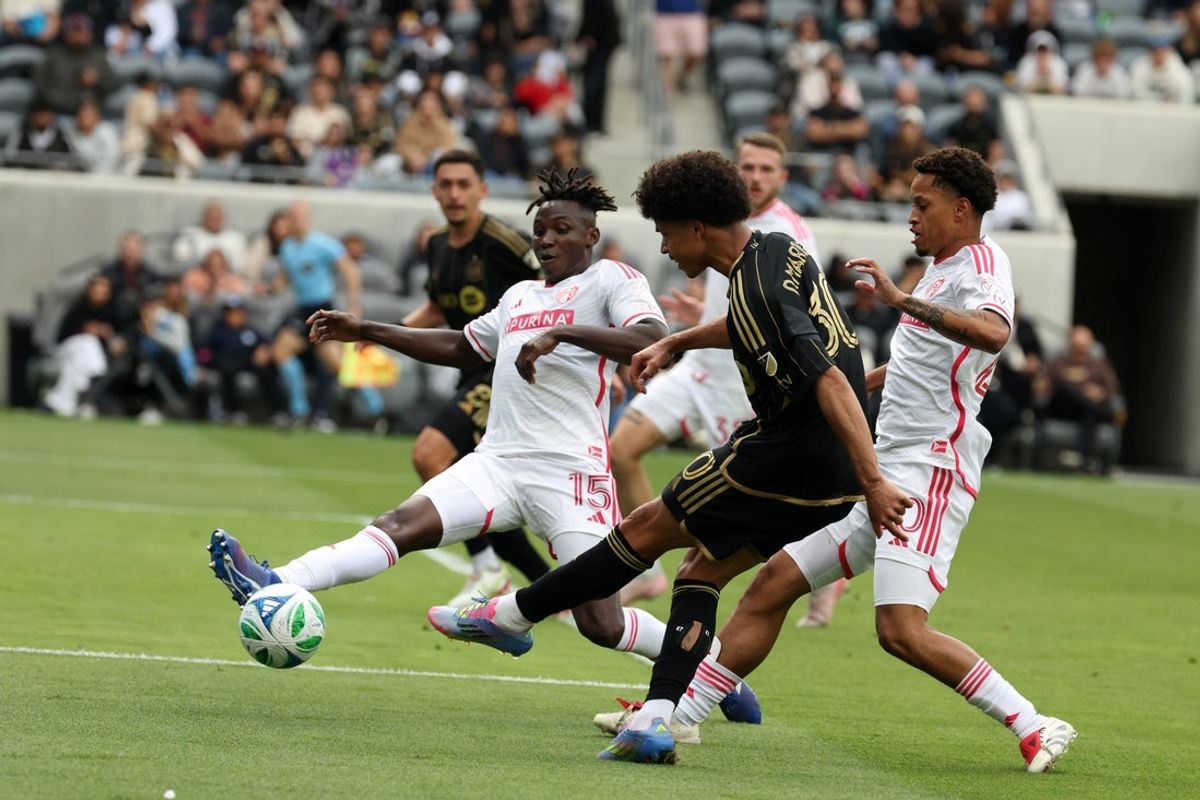 Apr 27, 2025; Los Angeles, California, USA;  LAFC forward David Martinez (30) shoots the ball as St. Louis CITY SC defender Josh Yaro (15) blocks during the first half at BMO Stadium. Mandatory Credit: Kiyoshi Mio-Imagn Images