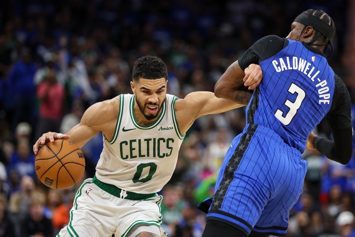 Apr 27, 2025; Orlando, Florida, USA; Boston Celtics forward Jayson Tatum (0) moves the ball past Orlando Magic guard Kentavious Caldwell-Pope (3) in the fourth quarter during game four of first round for the 2025 NBA Playoffs at Kia Center. Mandatory Credit: Nathan Ray Seebeck-Imagn Images