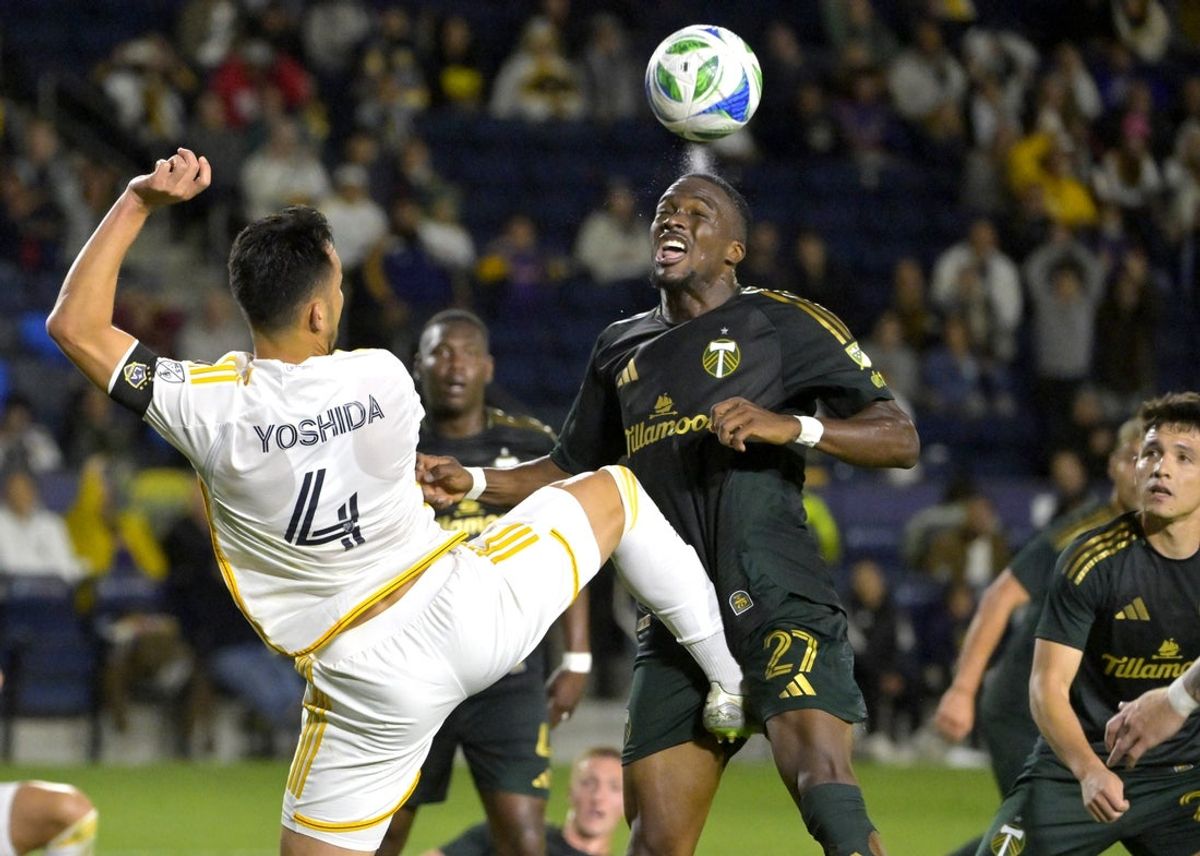 Apr 27, 2025; Carson, California, USA;  Portland Timbers midfielder Jimer Fory (27) is kicked by Los Angeles Galaxy defender Maya Yoshida (4) as he went for a pass in the second half at Dignity Health Sports Park. Mandatory Credit: Jayne Kamin-Oncea-Imagn Images