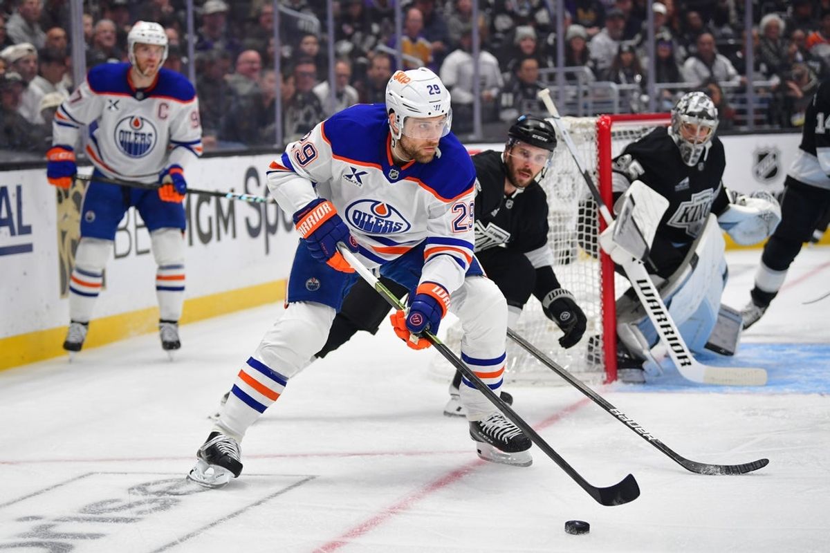 Apr 29, 2025; Los Angeles, California, USA; Edmonton Oilers center Leon Draisaitl (29) moves the puck against Los Angeles Kings right wing Adrian Kempe (9) during the first period in game five of the first round of the 2025 Stanley Cup Playoffs at Crypto.com Arena. Mandatory Credit: Gary A. Vasquez-Imagn Images