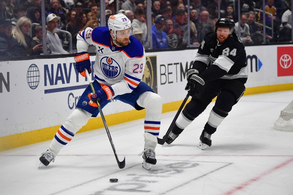 Apr 29, 2025; Los Angeles, California, USA; Edmonton Oilers center Leon Draisaitl (29) moves the puck against Los Angeles Kings defenseman Vladislav Gavrikov (84) during the first period in game five of the first round of the 2025 Stanley Cup Playoffs at Crypto.com Arena. Mandatory Credit: Gary A. Vasquez-Imagn Images
