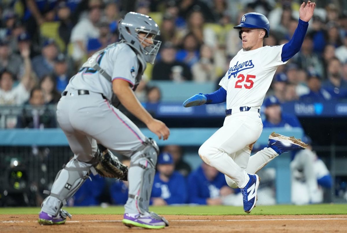 Apr 29, 2025; Los Angeles, California, USA; Los Angeles Dodgers second baseman Tommy Edman (25) scores against Miami Marlins catcher Agustin Ramirez (50) during the third inning at Dodger Stadium. Mandatory Credit: Kirby Lee-Imagn Images