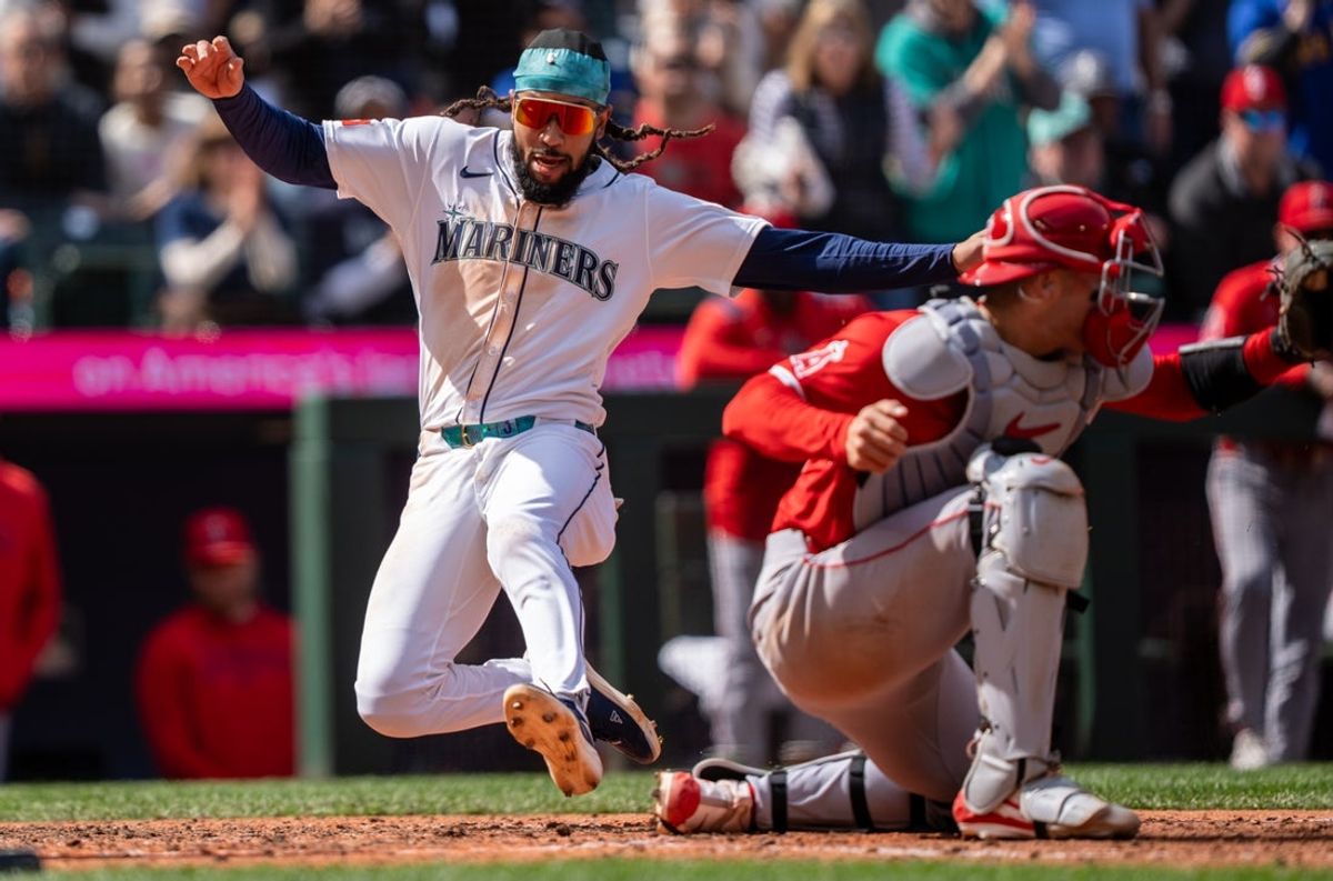 Apr 30, 2025; Seattle, Washington, USA;  Seattle Mariners shortstop J.P. Crawford (3), left, scores a run ahead of a tag by Los Angeles Angels catcher Logan O'Hoppe (14) during the seventh inning at T-Mobile Park. Mandatory Credit: Stephen Brashear-Imagn Images