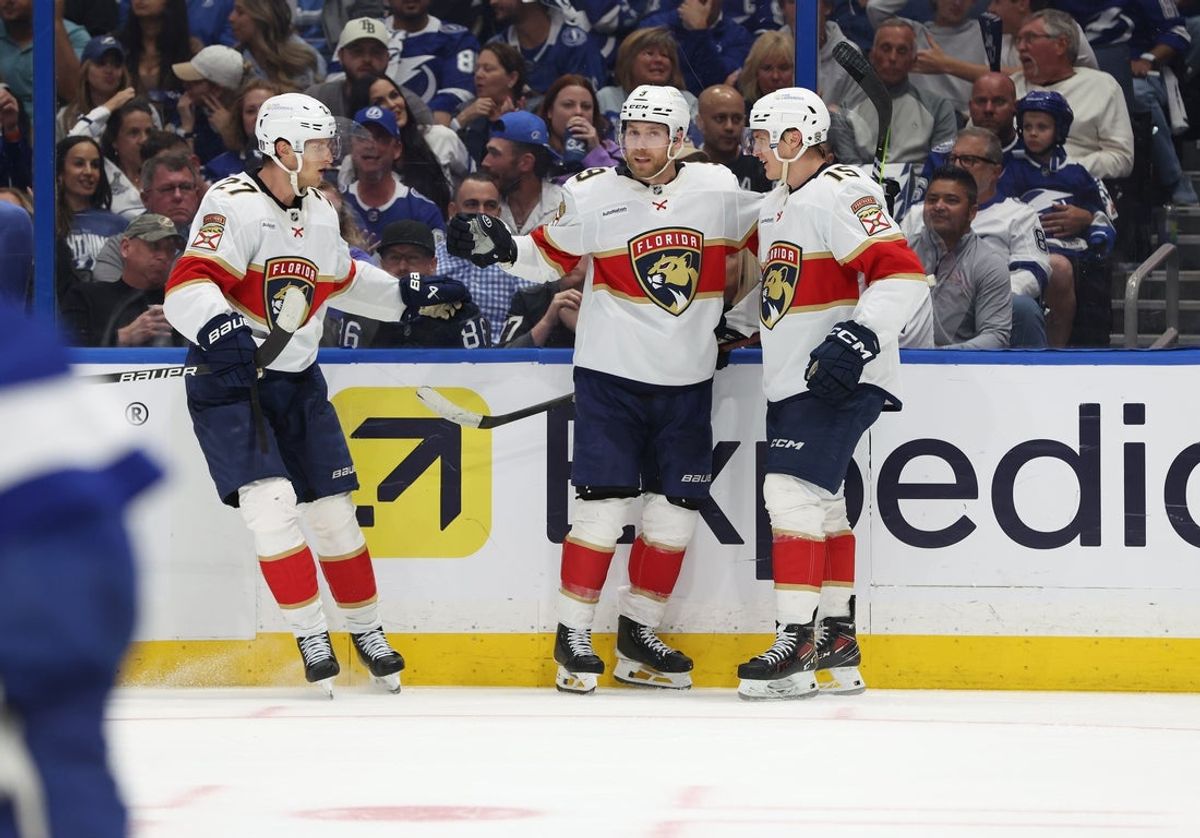 Apr 30, 2025; Tampa, Florida, USA; Florida Panthers center Sam Bennett (9) celebrates with center Eetu Luostarinen (27) and center Anton Lundell (15) after he scored a goal against the Tampa Bay Lightning  during the second period of game five of the first round of the 2025 Stanley Cup Playoffs at Amalie Arena. Mandatory Credit: Kim Klement Neitzel-Imagn Images