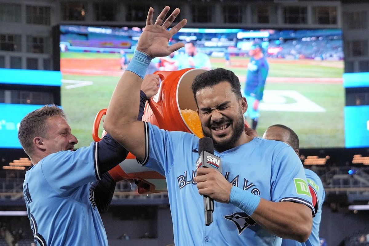 Apr 30, 2025; Toronto, Ontario, CAN; Toronto Blue Jays designated hitter Anthony Santander (25) reacts before getting doused with Gatorade by left fielder Myles Straw (3) and first baseman Vladimir Guerrero (27) following an extra inning win over the Boston Red Sox at Rogers Centre. Mandatory Credit: John E. Sokolowski-Imagn Images