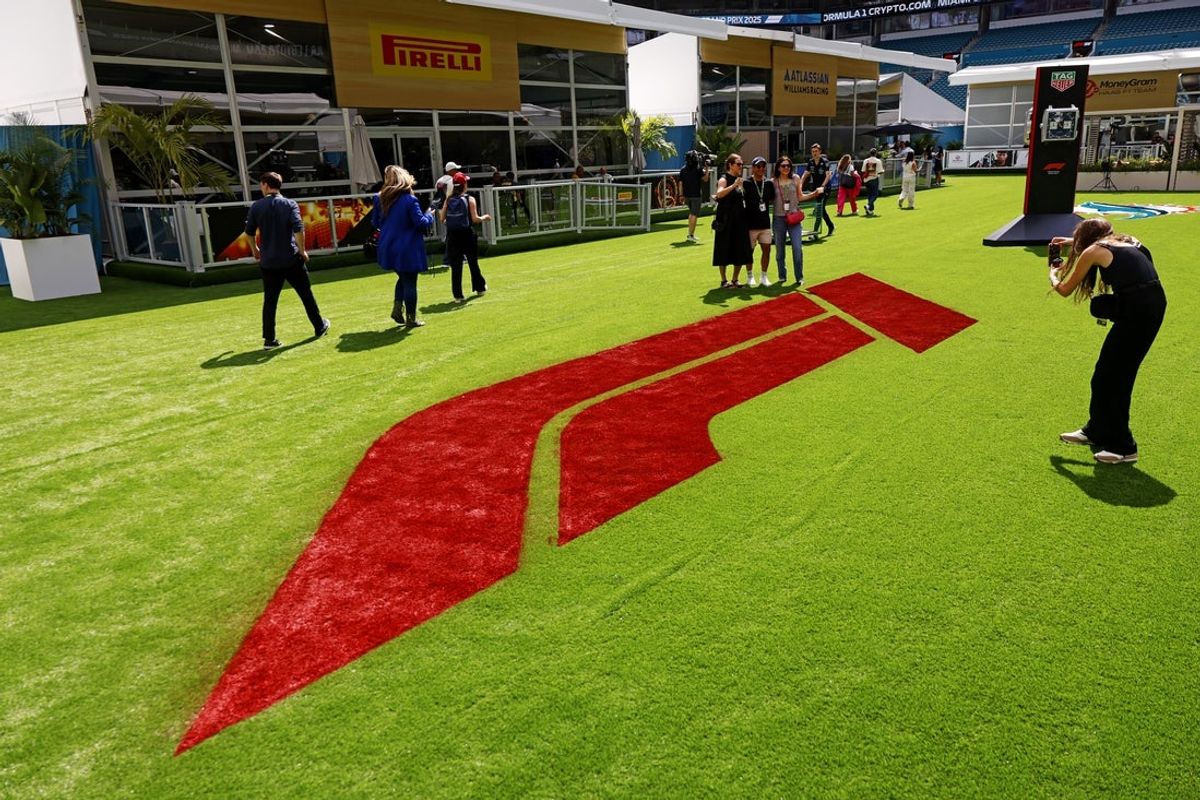 May 1, 2025; Miami Gardens, FL, USA; Fans pose for a picture in front of the F1 logo in the team village ahead of the F1 Miami Grand Prix at Miami International Autodrome. Mandatory Credit: Peter Casey-Imagn Images