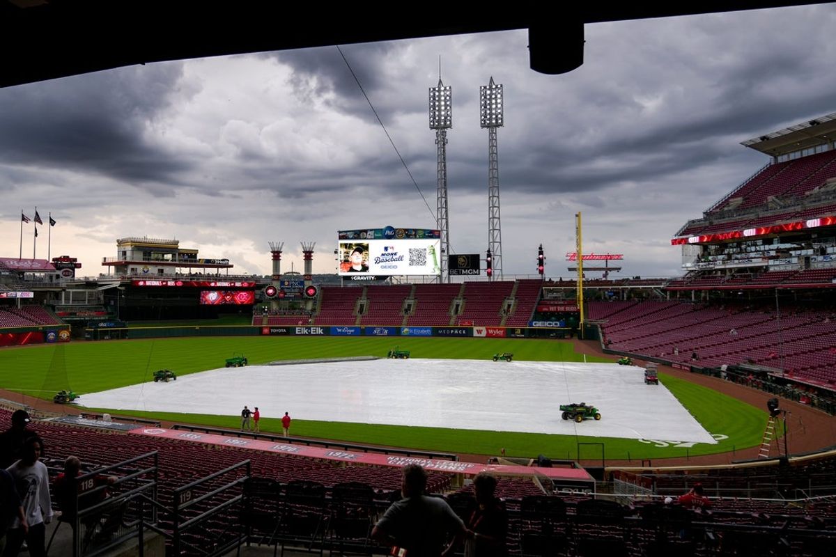 Fans make their ways into the stadium as a rain delay is announced before the first inning of the MLB National League game between the Cincinnati Reds and the Washington Nationals at Great American Ball Park in downtown Cincinnati on Friday, May 2, 2025.