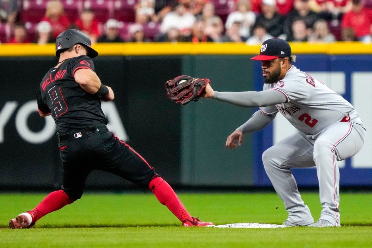 Cincinnati Reds second baseman Matt McLain (9) beats a pickoff tag from Washington Nationals second baseman Luis García Jr. (2) in the first inning of the MLB National League game between the Cincinnati Reds and the Washington Nationals at Great American Ball Park in downtown Cincinnati on Friday, May 2, 2025.
