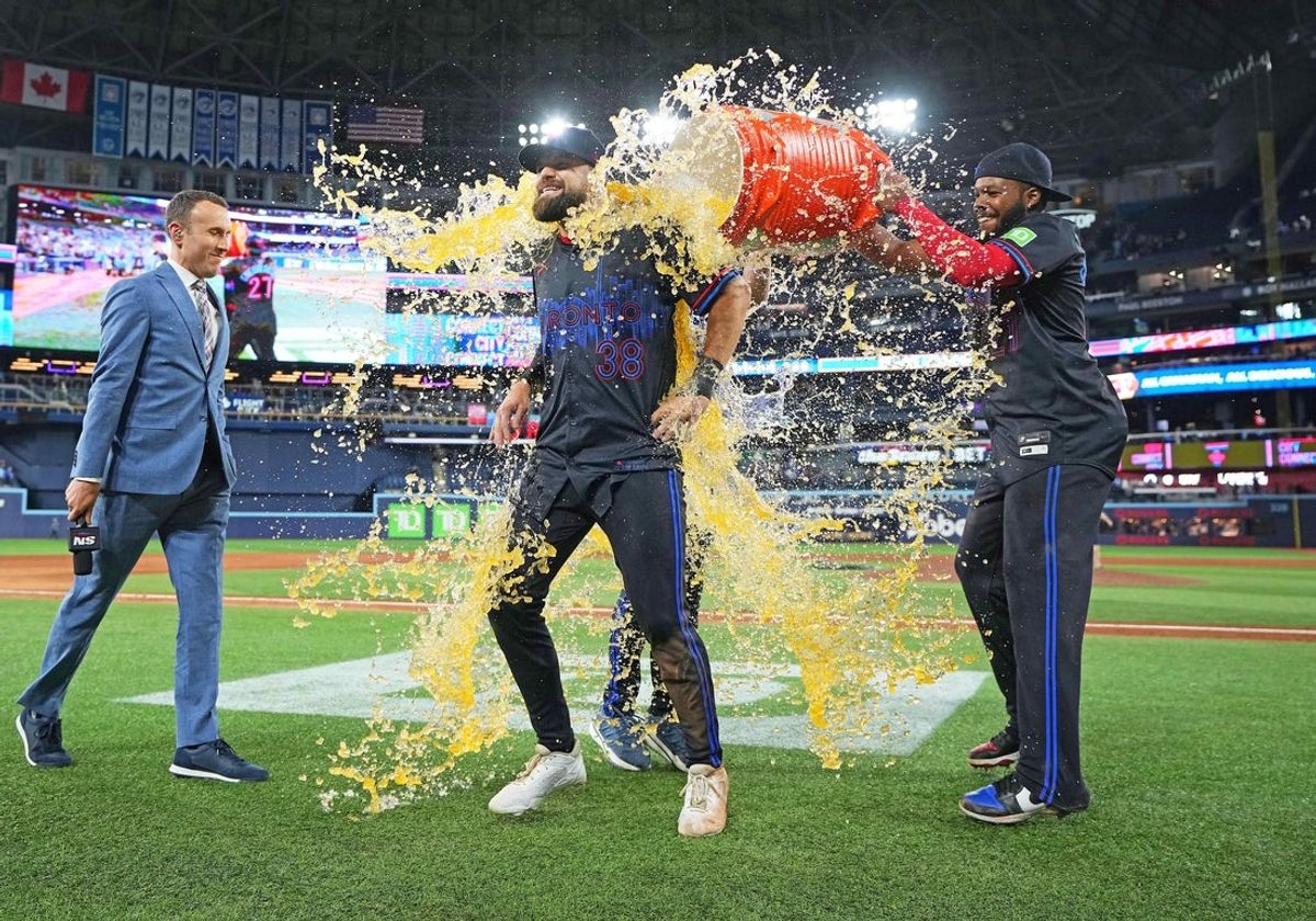 May 2, 2025; Toronto, Ontario, CAN; Toronto Blue Jays first base Vladimir Guerrero Jr. (27) pours the ice bucket on  pinch hitter and centre fielder Nathan Lukes (38) against the Cleveland Guardians at the end of the ninth inning at Rogers Centre. Mandatory Credit: Nick Turchiaro-Imagn Images