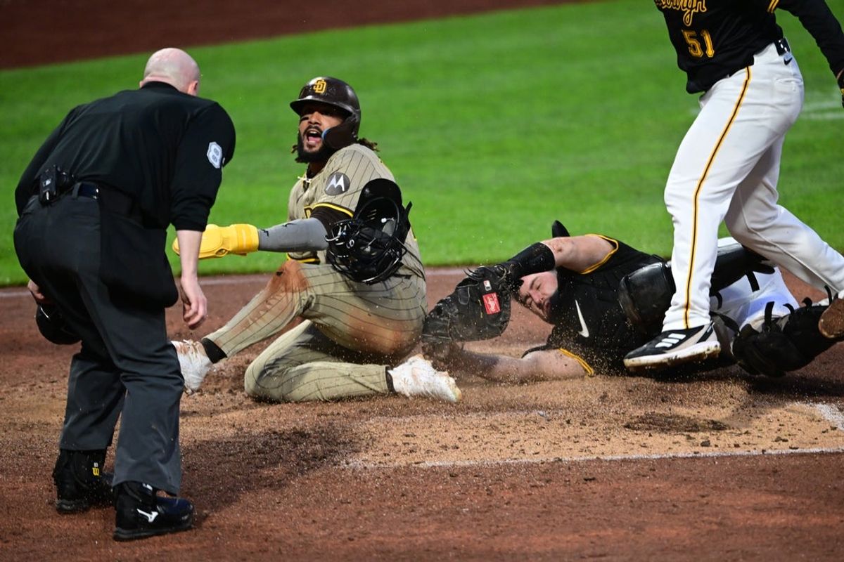 May 3, 2025; Pittsburgh, Pennsylvania, USA; San Diego Padres right fielder Fernando Tatis Jr. (23) beats a tag by Pittsburgh Pirates catcher Joey Bart (14) to score a run after a wild pitch by relief pitcher David Bednar (51) during the ninth inning at PNC Park. Mandatory Credit: David Dermer-Imagn Images