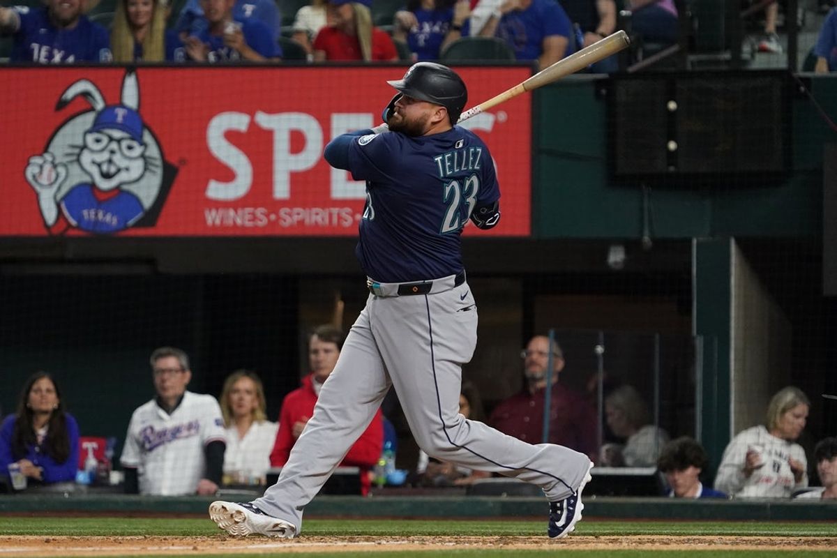 May 3, 2025; Arlington, Texas, USA; Seattle Mariners first baseman Rowdy Tellez (23) hits an RBI single during the ninth inning against the Texas Rangers at Globe Life Field. Mandatory Credit: Raymond Carlin III-Imagn Images
