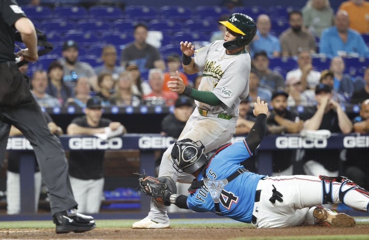 May 4, 2025; Miami, Florida, USA; Oakland Athletics third baseman Gio Urshela (13) is tagged out at the plate by Miami Marlins catcher Nick Fortes (4) during the second inning at loanDepot Park. Mandatory Credit: Rhona Wise-Imagn Images