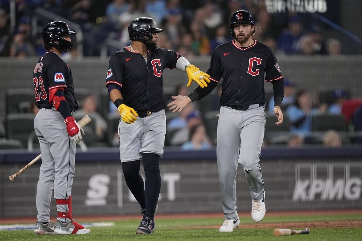 May 4, 2025; Toronto, Ontario, CAN; Cleveland Guardians designated hitter Carlos Santana (left) and second baseman Daniel Schneemann (right)  celebrate scoring against the Toronto Blue Jays on a single by Cleveland Guardians shortstop Gabriel Arias (not pictured) during the fourth inning at Rogers Centre. Mandatory Credit: John E. Sokolowski-Imagn Images