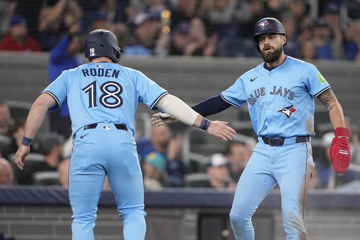 May 4, 2025; Toronto, Ontario, CAN; Toronto Blue Jays left fielder Alan Roden (18) and center fielder Nathan Lukes (38) celebrate scoring on a single by Toronto Blue Jays second baseman Andres Gimenez (not pictured) during the fourth inning against the Cleveland Guardians at Rogers Centre. Mandatory Credit: John E. Sokolowski-Imagn Images