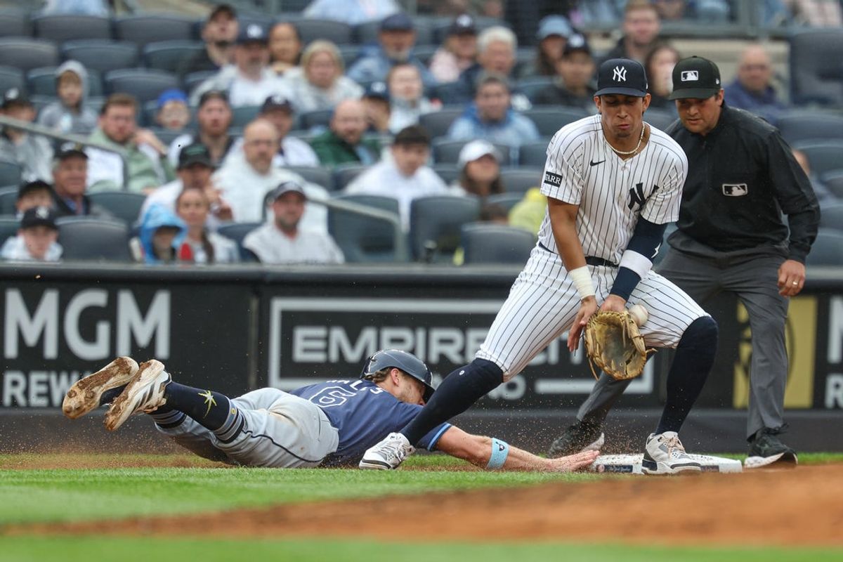 May 4, 2025; Bronx, New York, USA; Tampa Bay Rays shortstop Taylor Walls (6) slides safely back to third base as New York Yankees third baseman Oswaldo Cabrera (95) can to control a throw during the fifth inning at Yankee Stadium. Mandatory Credit: Vincent Carchietta-Imagn Images