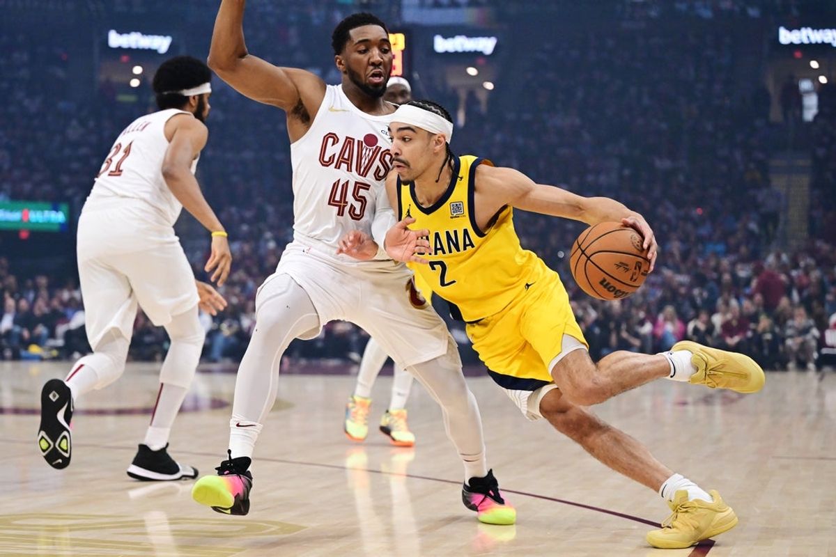 May 4, 2025; Cleveland, Ohio, USA; Indiana Pacers guard Andrew Nembhard (2) drives to the basket against Cleveland Cavaliers guard Donovan Mitchell (45) during the first quarter in game one of the second round for the 2025 NBA Playoffs at Rocket Arena. Mandatory Credit: Ken Blaze-Imagn Images