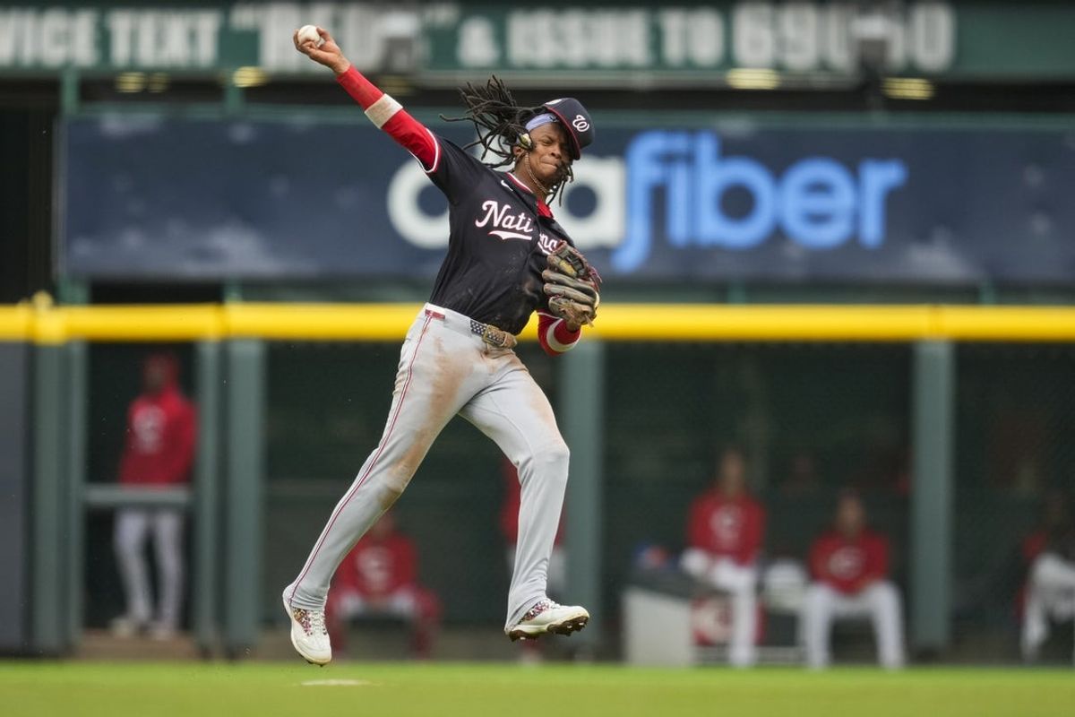 May 4, 2025; Cincinnati, Ohio, USA;  Washington Nationals shortstop CJ Abrams (5) fields the ball and attempts to throw out Cincinnati Reds outfielder Spencer Steer (7) in the fourth inning at Great American Ball Park. Mandatory Credit: Aaron Doster-Imagn Images