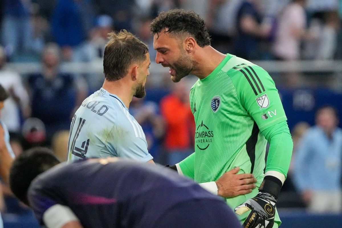 May 4, 2025; Kansas City, Kansas, USA; Sporting Kansas City goalkeeper John Pulskamp (1) celebrates with defender Tim Leibold (14) after the win over the LA Galaxy during the second half at Children's Mercy Park. Mandatory Credit: Denny Medley-Imagn Images