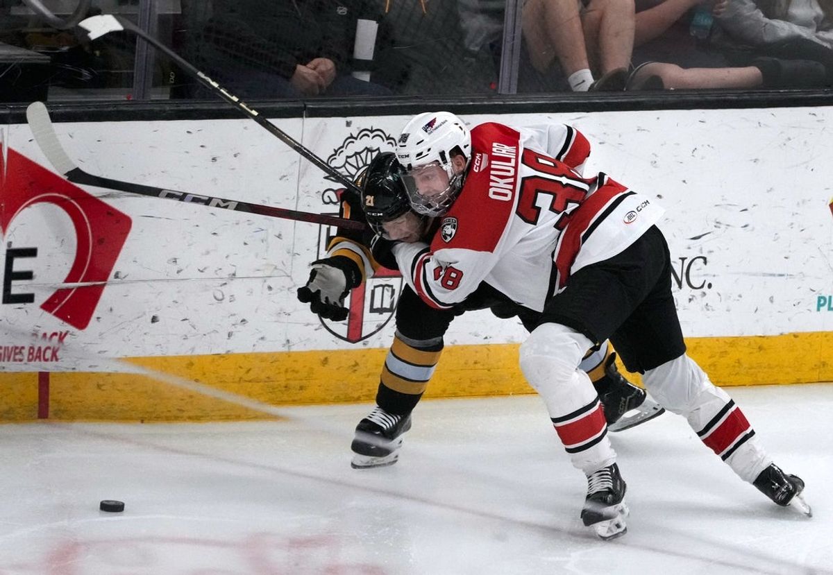 Providence Bruin Matthew Poitras gets wrapped up by Charlottte wing Oliver Okuliar in the second period.