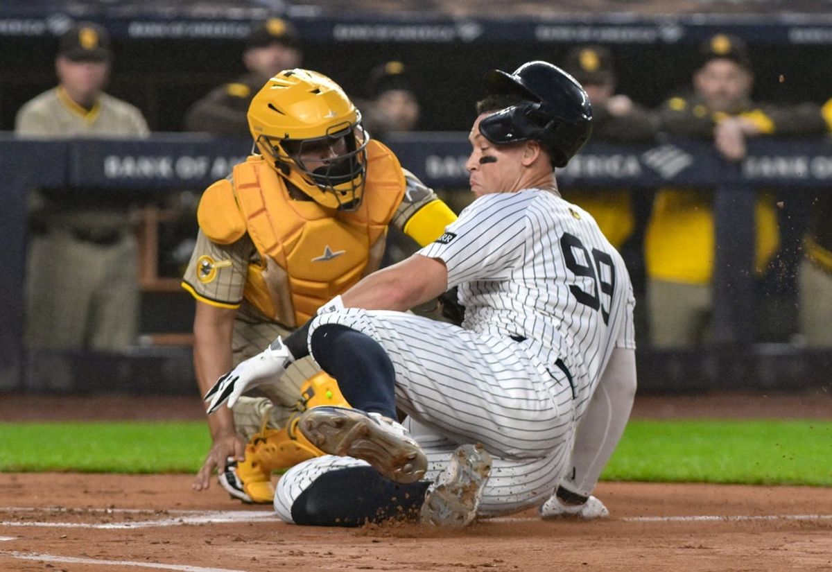 May 5, 2025; Bronx, New York, USA; New York Yankees outfielder Aaron Judge (99) is tagged out at home by San Diego Padres shortstop Xander Bogaerts (2) while trying to score on a double by first baseman Ben Rice (not pictured) during the first inning at Yankee Stadium. Mandatory Credit: John Jones-Imagn Images