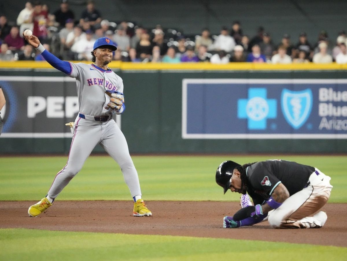 New York Mets shortstop Francisco Lindor (12) throws to first to complete a double play as Arizona Diamondbacks Ketel Marte (4) ducks during the first inning at Chase Field, May 5, 2025.