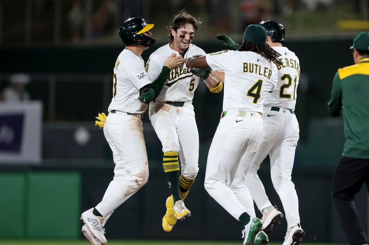 May 5, 2025; West Sacramento, California, USA; Athletics shortstop Jacob Wilson (5) is mobbed by teammates after hitting a RBI walk-off single against the Seattle Mariners during the eleventh inning at Sutter Health Park. Mandatory Credit: Dennis Lee-Imagn Images