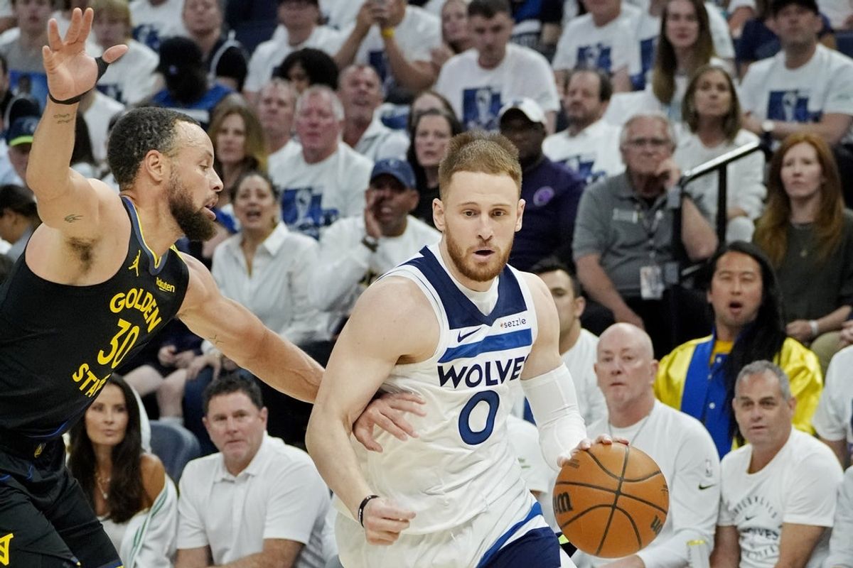 May 6, 2025; Minneapolis, Minnesota, USA; Minnesota Timberwolves guard Donte DiVincenzo (0) dribbles around Golden State Warriors guard Stephen Curry (30) in the first quarter during game one of the second round for the 2025 NBA Playoffs at Target Center. Mandatory Credit: Bruce Kluckhohn-Imagn Images