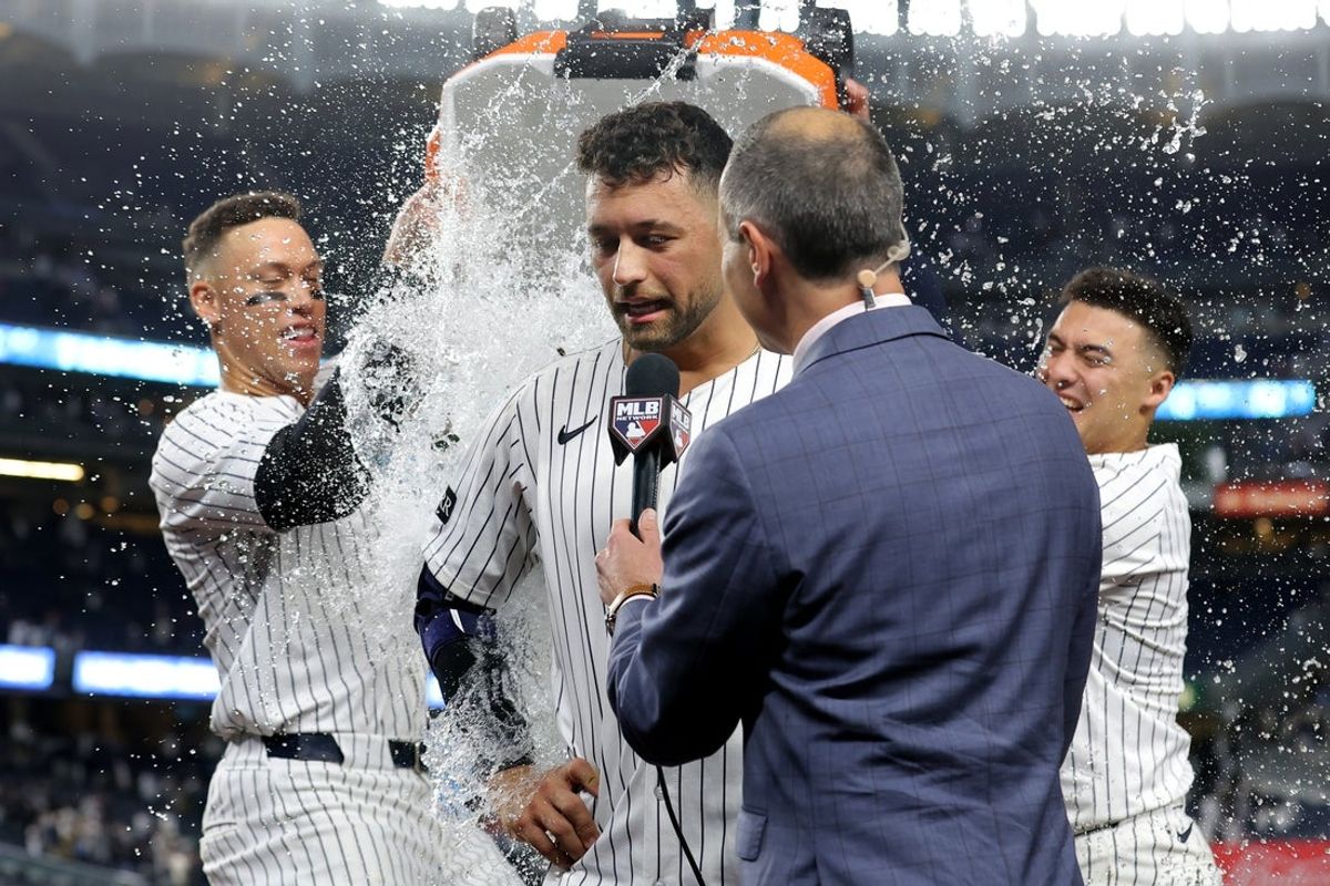 May 7, 2025; Bronx, New York, USA; New York Yankees pinch hitter J.C. Escarra (25) is doused by right fielder Aaron Judge (99) and shortstop Anthony Volpe (11) after hitting a tenth inning walkoff sacrifice fly against the San Diego Padres at Yankee Stadium. Mandatory Credit: Brad Penner-Imagn Images