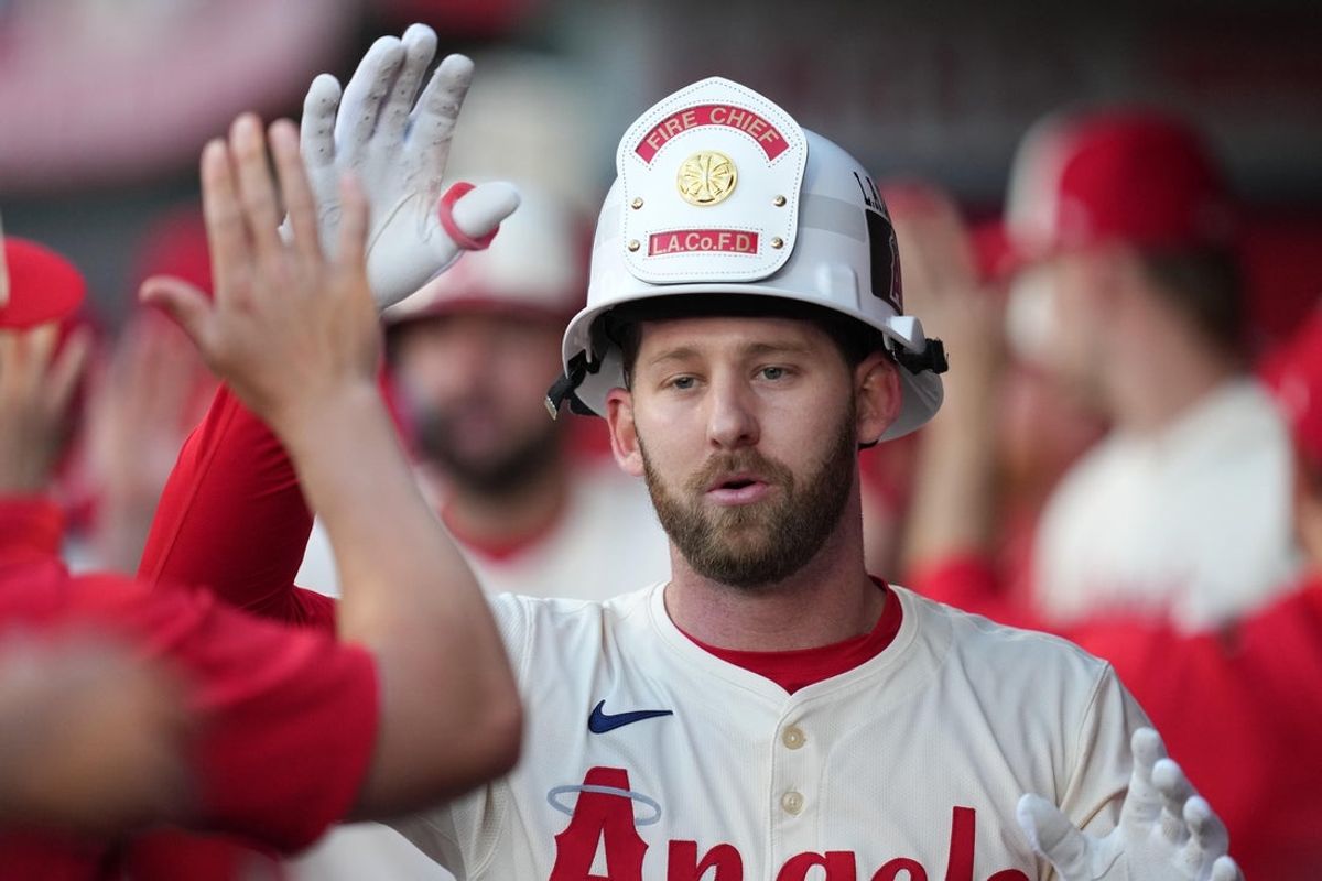 May 8, 2025; Anaheim, California, USA; Los Angeles Angels left fielder Taylor Ward (3) wears a Fireman helmet after hitting a two-run home run in the first inning against the Toronto Blue Jays at Angel Stadium. Mandatory Credit: Kirby Lee-Imagn Images