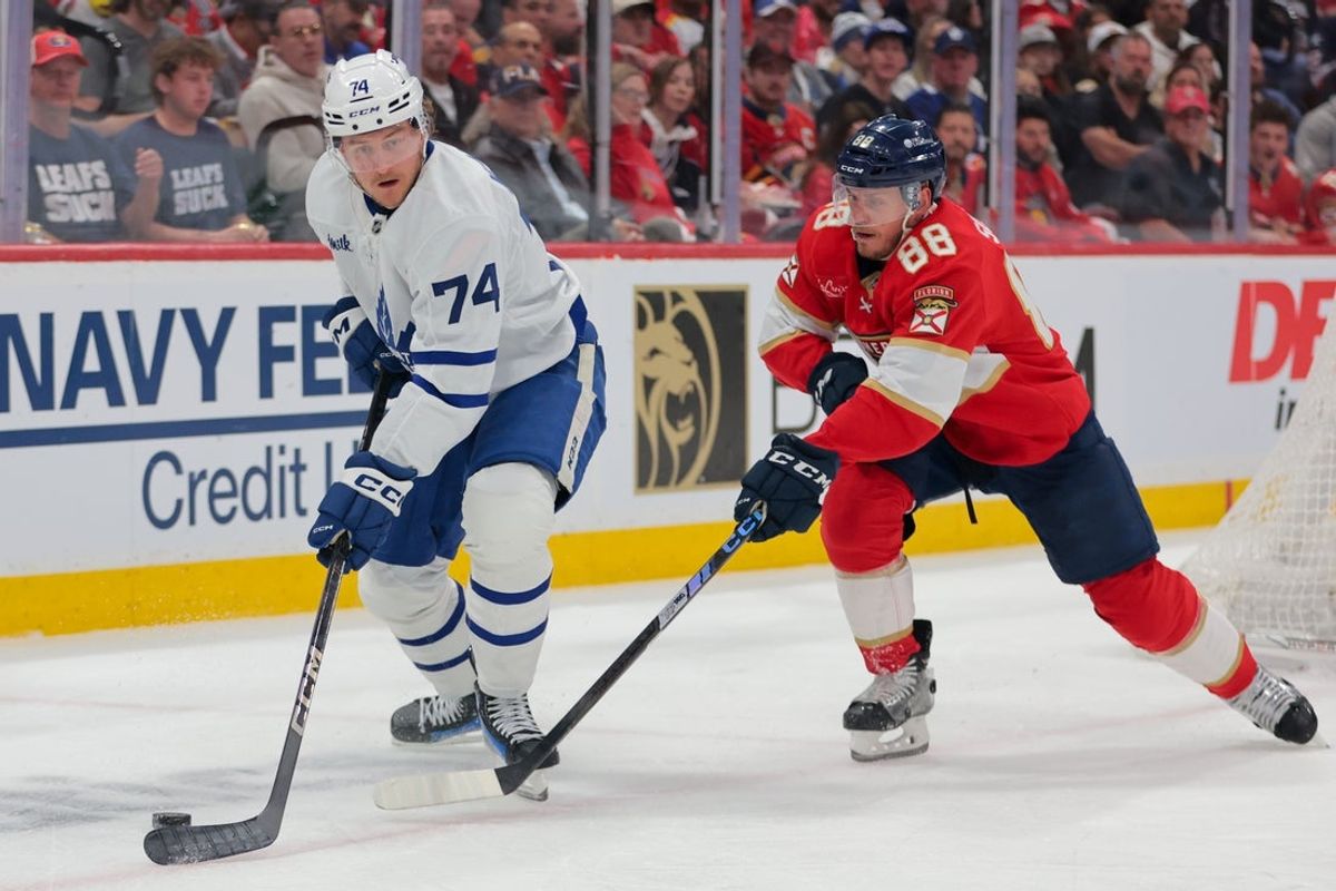May 9, 2025; Sunrise, Florida, USA; Toronto Maple Leafs center Bobby McMann (74) moves the puck past Florida Panthers defenseman Nate Schmidt (88) during the first period in game three of the second round of the 2025 Stanley Cup Playoffs at Amerant Bank Arena. Mandatory Credit: Sam Navarro-Imagn Images