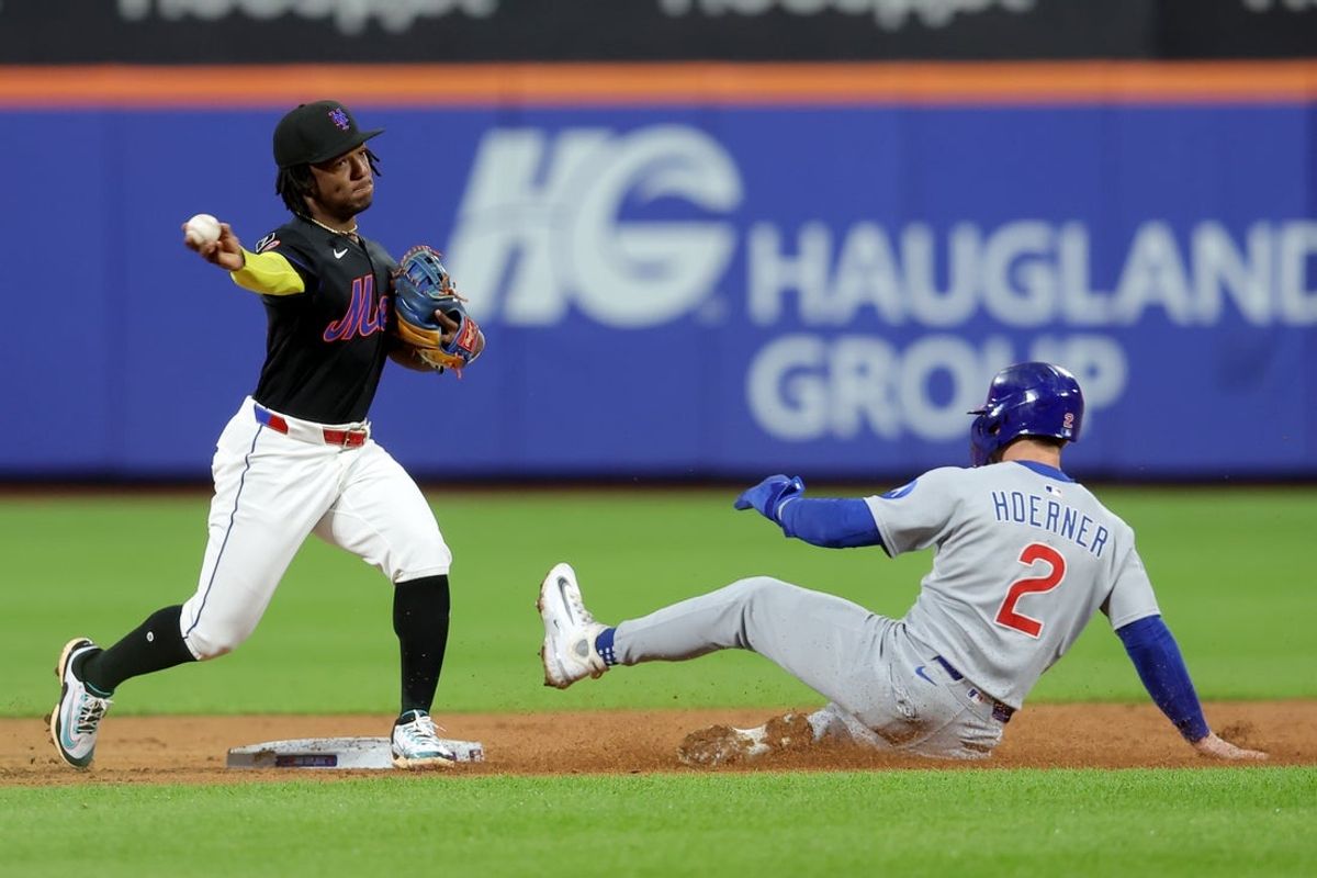 May 9, 2025; New York City, New York, USA; New York Mets second baseman Luisangel Acuna (2) forces out Chicago Cubs second baseman Nico Hoerner (2) at second and throws to first to complete a double play on a ball hit by Cubs shortstop Dansby Swanson (not pictured) during the third inning at Citi Field. Mandatory Credit: Brad Penner-Imagn Images