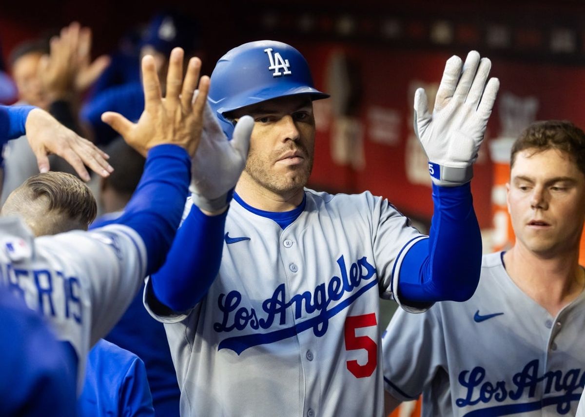 May 9, 2025; Phoenix, Arizona, USA; Los Angeles Dodgers first baseman Freddie Freeman celebrates with teammates after driving in a run with a sacrifice fly in the first inning against the Arizona Diamondbacks at Chase Field. Mandatory Credit: Mark J. Rebilas-Imagn Images
