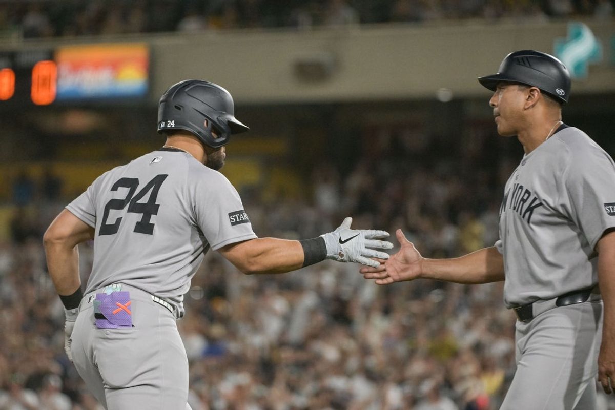 May 9, 2025; West Sacramento, California, USA; New York Yankees outfielder Jasson Dominguez (24) celebrates with third base/outfield coach Luis Rojas (67) after hitting a grand slam against the Athletics during the eighth inning at Sutter Health Park. Mandatory Credit: Ed Szczepanski-Imagn Images