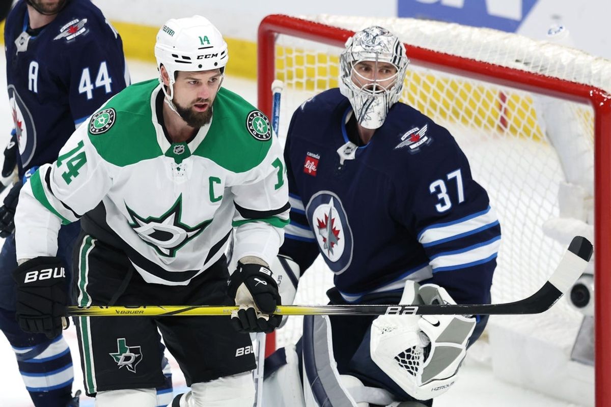 May 9, 2025; Winnipeg, Manitoba, CAN;Dallas Stars left wing Jamie Benn (14) and Winnipeg Jets goaltender Connor Hellebuyck (37) keep an eye on the play in the third period in game two of the second round of the 2025 Stanley Cup Playoffs at Canada Life Centre. Mandatory Credit: James Carey Lauder-Imagn Images