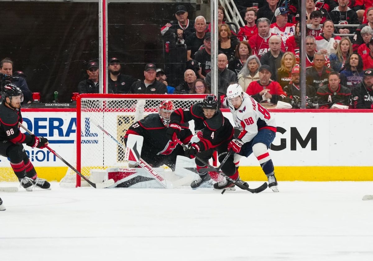 May 10, 2025; Raleigh, North Carolina, USA; Carolina Hurricanes defenseman Shayne Gostisbehere (4) pokes the puck away from Washington Capitals left wing Andrew Mangiapane (88) during the first period in game three of the second round of the 2025 Stanley Cup Playoffs at Lenovo Center. Mandatory Credit: James Guillory-Imagn Images