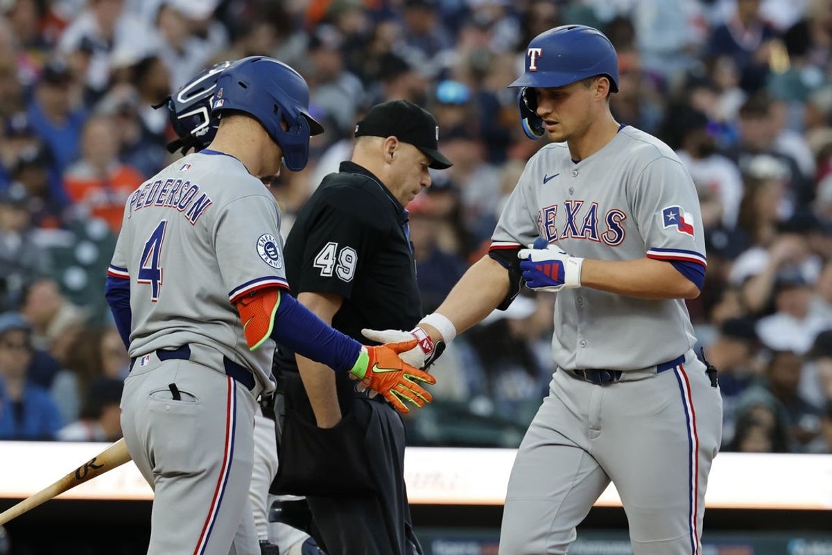 May 10, 2025; Detroit, Michigan, USA;  Texas Rangers shortstop Corey Seager (5) receives congratulations from designated hitter Joc Pederson (4) after he hits a home run in the sixth inning against the Detroit Tigers at Comerica Park. Mandatory Credit: Rick Osentoski-Imagn Images