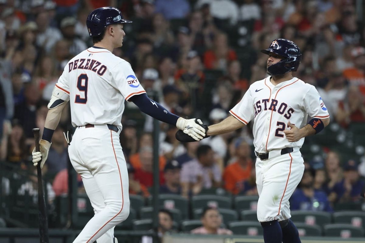 May 10, 2025; Houston, Texas, USA; Houston Astros second baseman Jose Altuve (27) celebrates with left fielder Zach Dezenzo (9) after scoring a run during the first inning against the Cincinnati Reds at Daikin Park. Mandatory Credit: Troy Taormina-Imagn Images