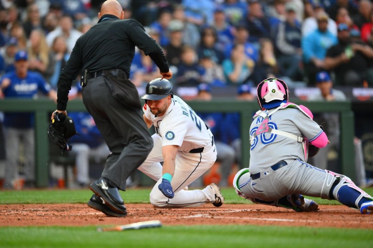 May 10, 2025; Seattle, Washington, USA; Seattle Mariners catcher Cal Raleigh (29) scores a run past Toronto Blue Jays catcher Alejandro Kirk (30) during the fourth inning at T-Mobile Park. Mandatory Credit: Steven Bisig-Imagn Images
