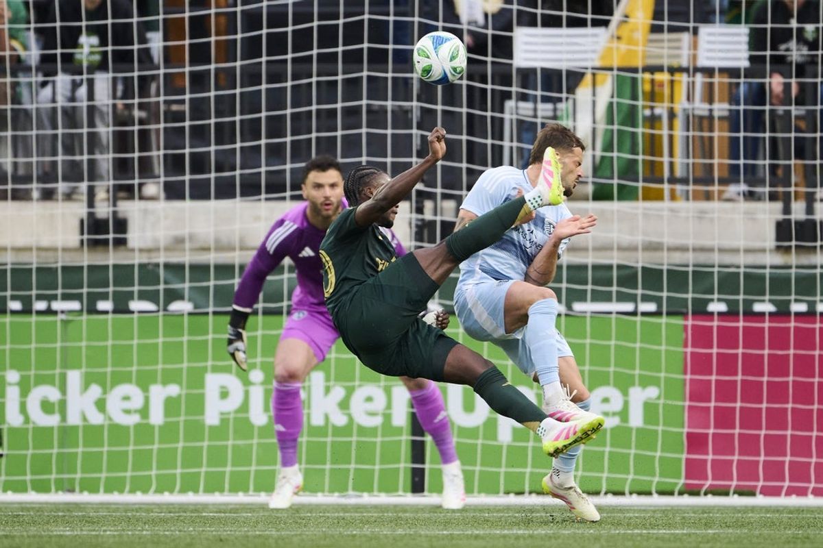 May 10, 2025; Portland, Oregon, USA; Portland Timbers midfielder Santiago Moreno (30) scores a goal against Sporting Kansas City defender Tim Leibold (14) during the first half at Providence Park. Mandatory Credit: Troy Wayrynen-Imagn Images